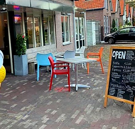 Terras van Cafetaria Groeneveld met tafels en stoelen aan de Loudelsweg in Bergen NH